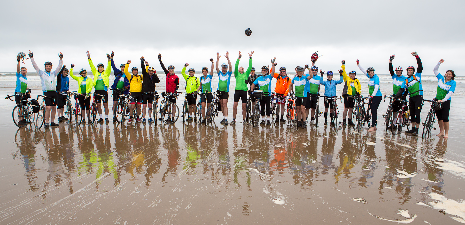 A large group of cyclists on the beach.