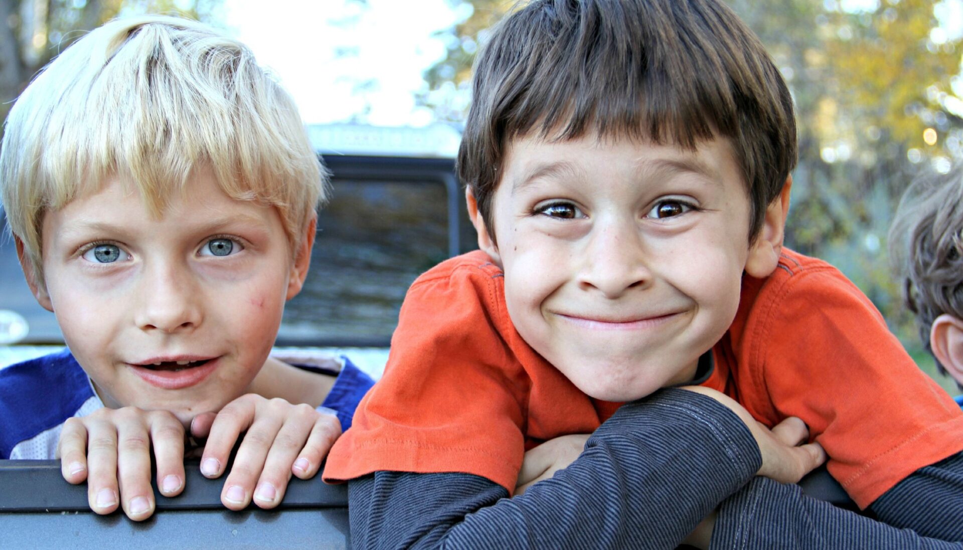 Two cheeky young boys looking at the camera grinning