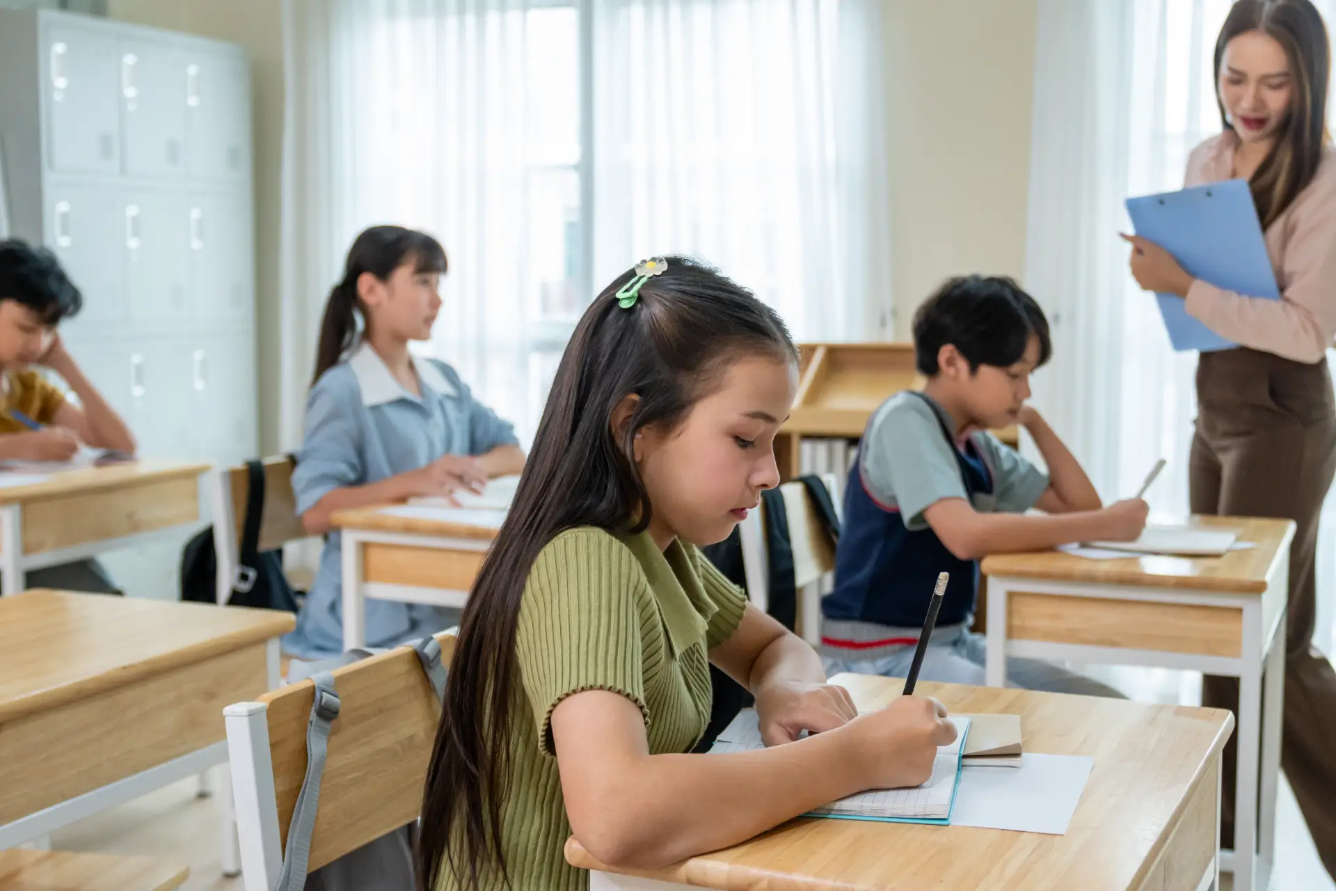 group-of-students-learning-with-teacher-in-classroom Group of student taking a test